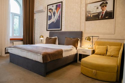 een slaapkamer met een bed en een stoel erin bij Zimmer Boutique Hotel in Baku