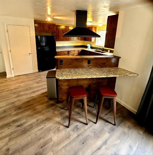 a kitchen with a large counter with two stools at The Gold Mine Cottage in Idaho City