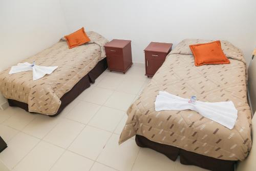 two beds with bow ties on them in a room at HOSTAL PUNTA ARENAS in Tarija