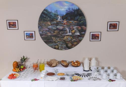 a table with food and a painting on the wall at HOSTAL PUNTA ARENAS in Tarija
