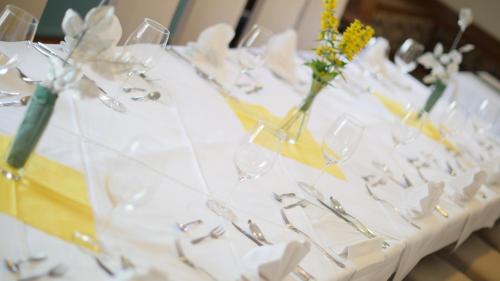 a table with glasses and vases with flowers on it at Eisenerzer Hof in Eisenerz