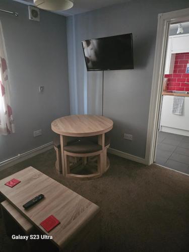 a room with a table and a tv on the wall at A Home From Home 3 in Plymouth