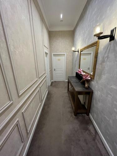 a hallway with a door and a table and a mirror at Zimmer Boutique Hotel in Baku