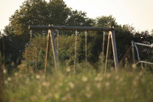 une ancienne balançoire installée dans un champ d'herbe dans l'établissement La Maison des Eyres - Gîte Le Fadet, à Pey