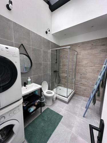 a bathroom with a shower toilet and a washing machine at Modern Family Apartment 20mins from Disney / 45mins from Paris in Lognes