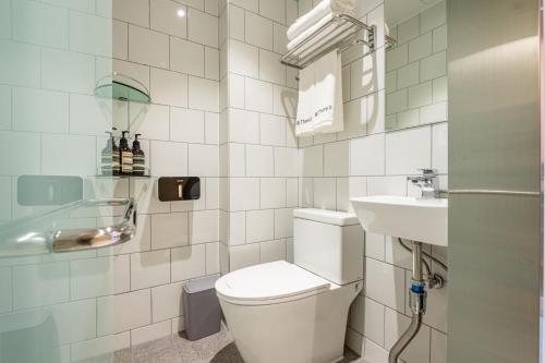 a white bathroom with a toilet and a sink at Hithere City Myeongdong in Seoul