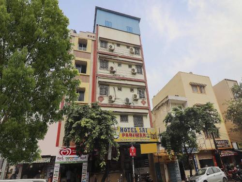 a tall building with a sign on the side of it at Hotel O Sai Pariwar in Vidya Nagar