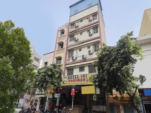 a tall pink building with a sign on it at Hotel O Sai Pariwar in Vidya Nagar