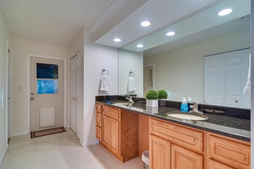 a bathroom with two sinks and a large mirror at Sunny Palm Harbor Home with Private Pool and Hot Tub! in Palm Harbor