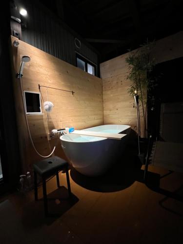 a bathroom with a tub and a stool in a room at 海宿ニシノヤ 