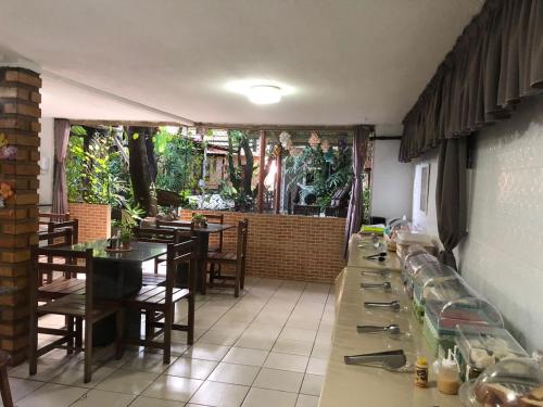 uma sala de jantar com mesa e cadeiras num restaurante em Hotel Pousada Casuarinas no Recife