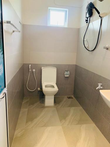 a bathroom with a toilet and a shower at Pearl Gardens Midigama in Midigama