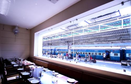 a dining room with a large window in a train station at Hotel Le Roi Raipur at Raipur Railway Station in Raipur