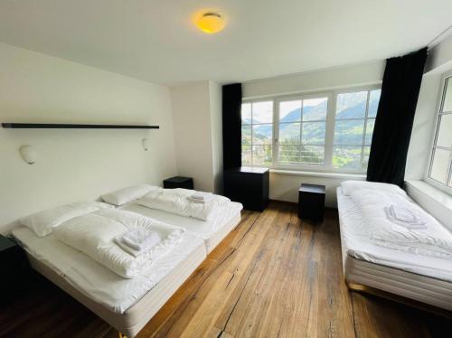 a bedroom with two beds and two windows at Breathtaking Alpine views near ski lifts spa 135m2 in Bad Gastein