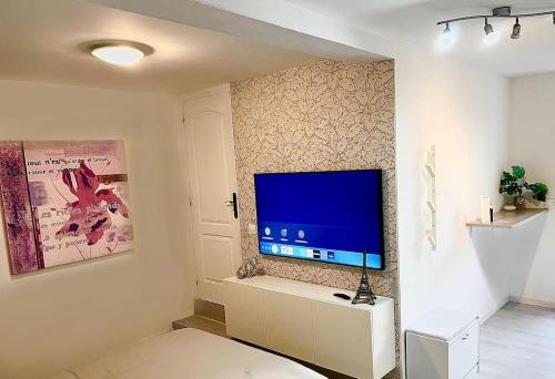uma sala de estar com uma televisão de ecrã plano na parede em Maison du bonheur em Cagnes-sur-Mer
