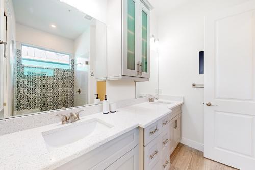 a white bathroom with two sinks and a mirror at Lavender Life in Saint James City