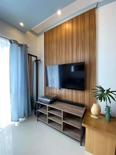 een woonkamer met een flatscreen-tv aan een houten muur bij La Casa De Modena in Minglanilla