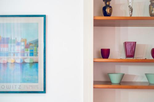 a framed picture on a shelf with vases at Al Castello di San Giusto free garage in Trieste