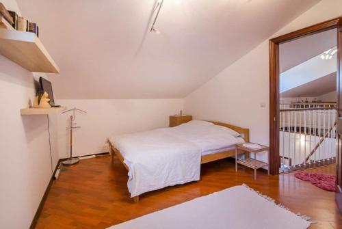 a bedroom with a white bed and a staircase at Barrio tranquilo, wifi de fibra óptica, metro y autobús. in Almería