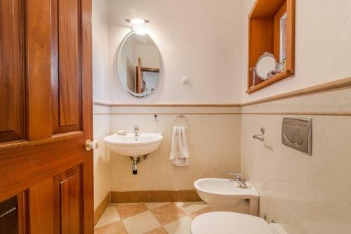 a bathroom with a toilet and a sink and a mirror at Barrio tranquilo, wifi de fibra óptica, metro y autobús. in Almería