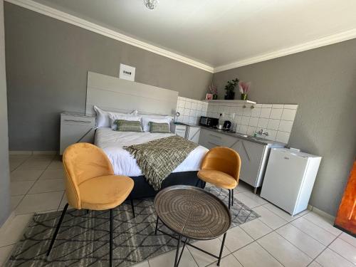 um quarto com uma cama, uma mesa e cadeiras em Sentle Boutique Stay em Kuruman