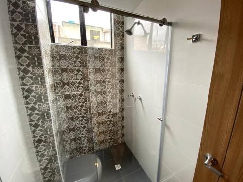 a shower with a glass door in a bathroom at Hermoso Apartaestudio Duplex cerca a Unicentro in Pasto