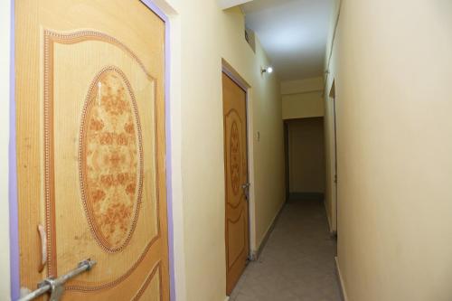 a door in a hallway with a hallway leading to a room at OYO Flagship Hotel New Urvashi in Hājīpur