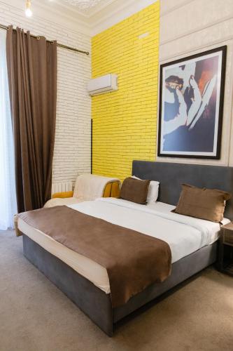 a bedroom with two beds and a yellow wall at Zimmer Boutique Hotel in Baku