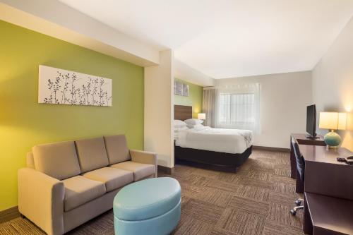 Habitación de hotel con cama y sofá en Sleep Inn & Suites North Mobile Saraland, en Saraland