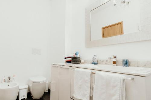 a white bathroom with a sink and a toilet at Al Castello di San Giusto free garage in Trieste