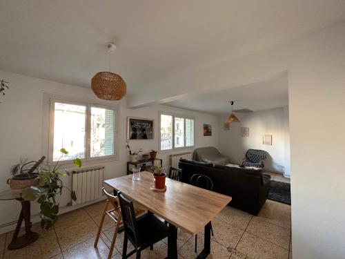 un salon avec une table et un canapé dans l'établissement Chambres dans Grand Appartement - Centre-ville, à Montpellier