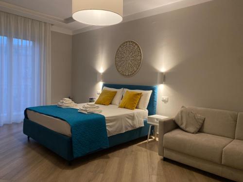 un dormitorio con una cama y un sofá en Luna Nuova Suites, en Nápoles