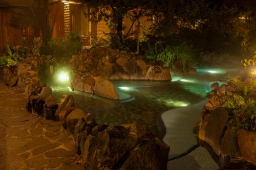 a pool with rocks in a yard at night at Termas de Papallacta in Papallacta