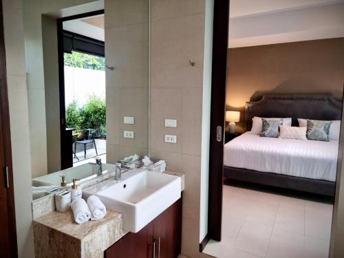 a bathroom with a sink and a bed and a mirror at Horizon Vista Pool Villa Family Retreat Bangtao in Phuket Town