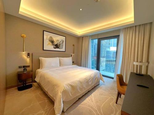 a bedroom with a bed and a desk and a window at Dreamy 2BR Haven, Downtown Bliss in Dubai