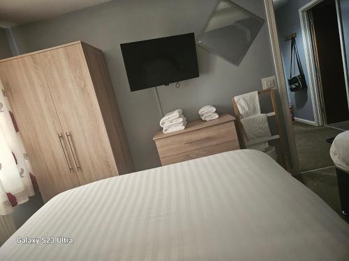 a bedroom with a bed and a tv on a wall at A Home From Home 3 in Plymouth