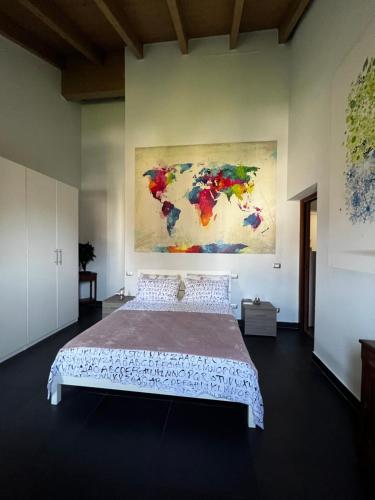 una camera da letto con un grande letto e un dipinto sul muro di Casa Ely a Pegognaga