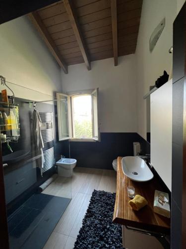 baño con lavabo y aseo y ventana en Casa Ely, en Pegognaga