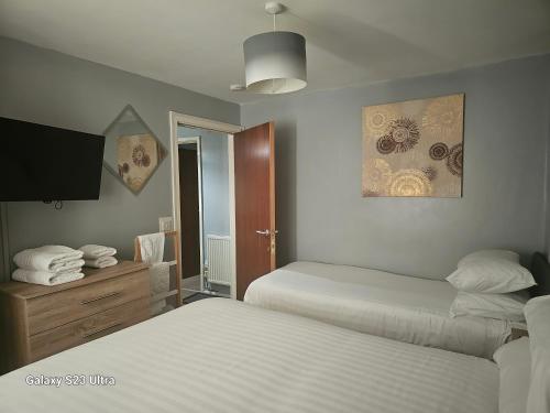 Habitación de hotel con 2 camas y TV en A Home From Home 3, en Plymouth