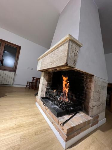 a brick fireplace with a fire in a room at Casa familiar en la playa con piscina in Teià