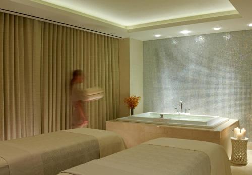 a woman in a hotel room with two beds and a tub at The Dominick Hotel in New York