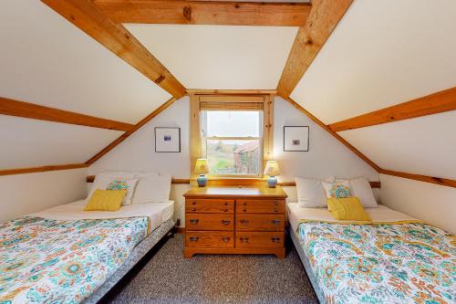 two beds in a attic bedroom with a window at Running Fox Farm in Baraboo