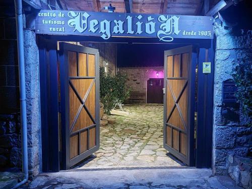 una entrada a un edificio con 2 puertas de madera en Hotel Moto-Rural "VEGALION", en Las Salas