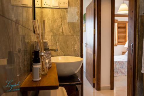 a bathroom with a white bowl sink on a counter at Lavish Livin’ in Galle