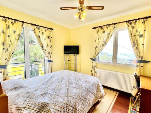 um quarto com uma cama e duas janelas em Casa Amarela by Your Madeira Rentals em Ponta do Sol