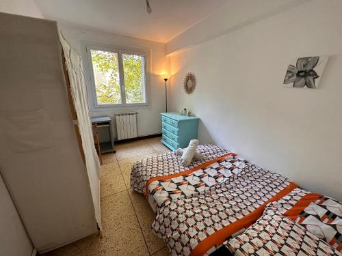 - une chambre avec 2 lits jumeaux et une fenêtre dans l'établissement Chambres dans Grand Appartement - Centre-ville, à Montpellier