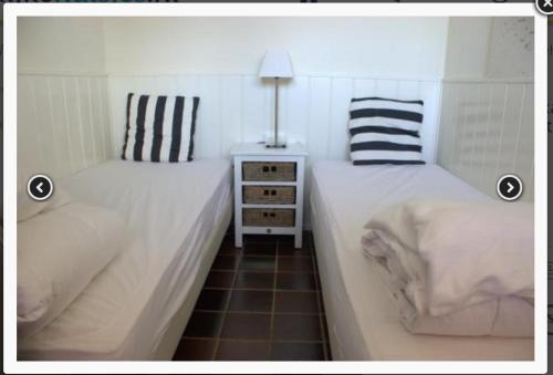 dos camas sentadas una al lado de la otra en un dormitorio en Vakantiebungalow in Riviera Maison stijl nabij zee en strand, bos en duin, en Warmenhuizen