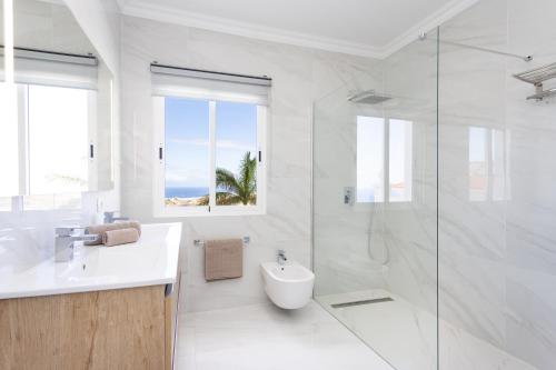 ein weißes Bad mit einem Waschbecken und einer Dusche in der Unterkunft Villa Exotica in Adeje