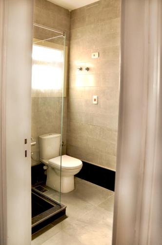 a bathroom with a toilet and a glass shower at Cozy apartments in Coraya Bay