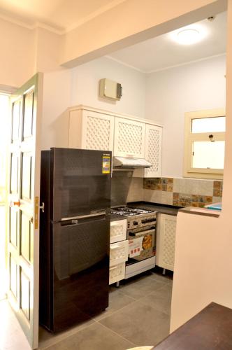 a kitchen with a black refrigerator and a stove at Cozy apartments in Coraya Bay
